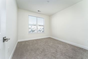 an empty room with a window and carpet